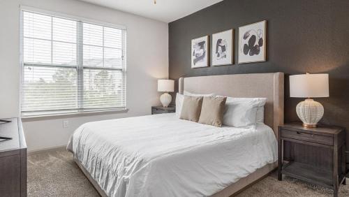 a bedroom with a bed and two lamps and a window at Landing at Perry Street Lofts - 2 Bedrooms in Petersburg in Petersburg