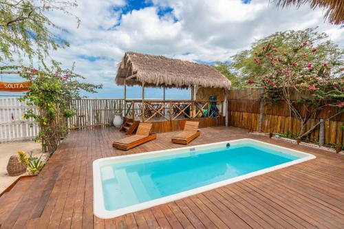 una piscina su una terrazza in legno con capanna di Solita beach bungalow - kite spot a Macau