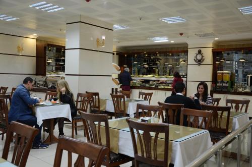 a group of people sitting at tables in a restaurant at Gumus Palace Hotel in Istanbul
