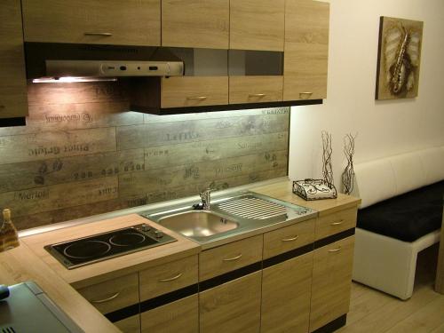 a kitchen with a sink and a stove in it at Korzó Apartman in Kőszeg