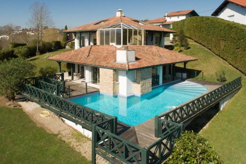 une maison avec piscine sur un pont dans l'établissement Villa Ongizatea au calme avec piscine et vue montagne, à Urrugne