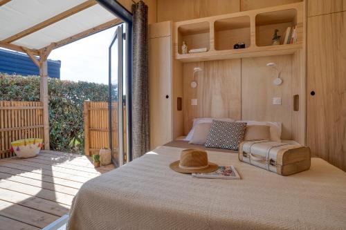 a bedroom with a bed with a hat on it at Slow Village Breizh Légendes in Plounéour-Trez
