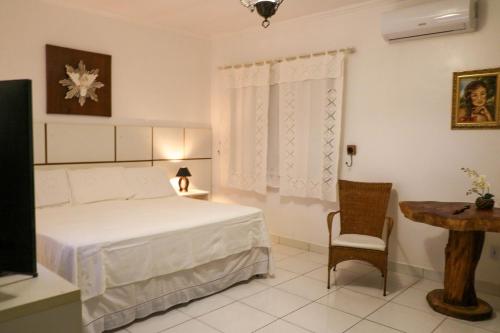 Olho D’Água do CasadoにあるRancho Império do Cajúのベッドと椅子とテーブルのある寝室