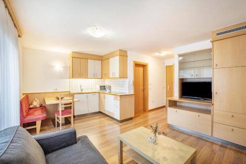 a kitchen and living room with a couch and a table at Residence Linderhof in Naz-Sciaves