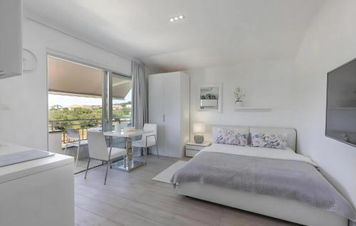 a white bedroom with a bed and a table and chairs at Lalic Gallery Villa in Bibinje