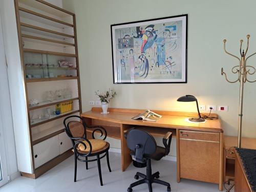 a home office with a wooden desk and two chairs at Villa La Blanca in Pellaro