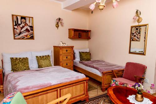 a bedroom with two beds and a chair at Apartamenty Molus na Rynku Staromiejskim in Toruń