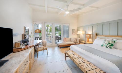 a bedroom with a bed and a living room at Islander Resort in Islamorada