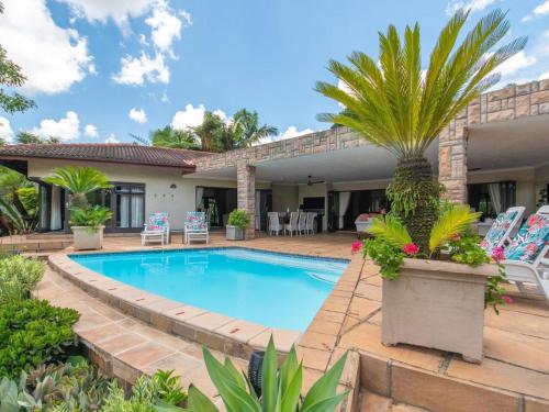 una villa con piscina y palmeras en African Dream Villa, en White River