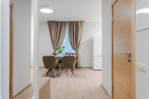 a dining room with a table and chairs and a window at Quiet Garden in Rīga