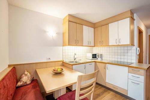 a small kitchen with a table and a couch at Residence Linderhof in Naz-Sciaves
