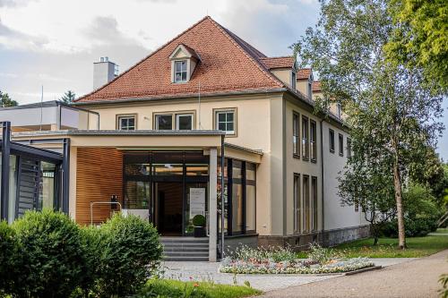 a large house with a roof at Hotel Kurhaus Bad Bocklet in Bad Bocklet