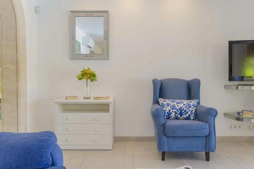 a blue chair in a living room with a mirror at Villa Biel in Pollença