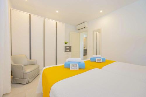 a white bedroom with a bed and a chair at Villa Biel in Pollença