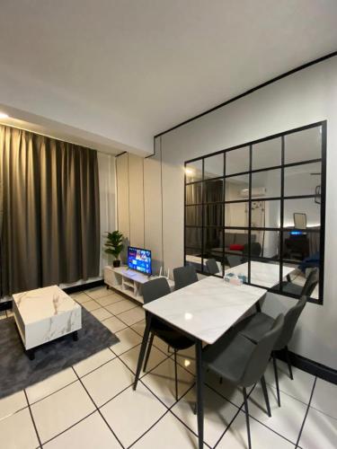 a living room with a table and chairs and a television at Studio with Rooftop Pool at Youth City Nilai by D'KAY HOMES, near USIM KLIA in Nilai