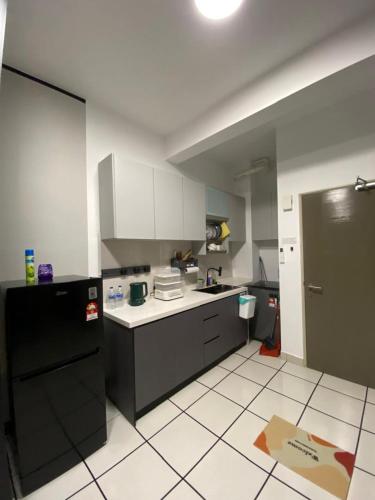 a kitchen with a black refrigerator and a white tile floor at Studio with Rooftop Pool at Youth City Nilai by D'KAY HOMES, near USIM KLIA in Nilai