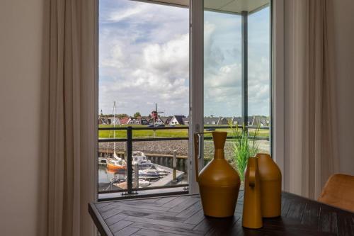 two vases sitting on a table in front of a window at Vakantiewoning aan het water - met 2 balkons - Vista Maris - Nr 38 in Sint Annaland