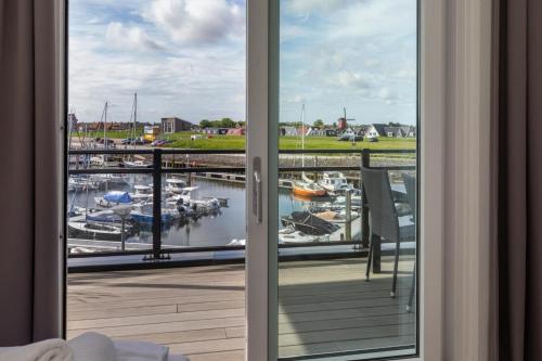 a view of a marina from a room with a window at Vakantiewoning aan het water - met 2 balkons - Vista Maris - Nr 38 in Sint Annaland
