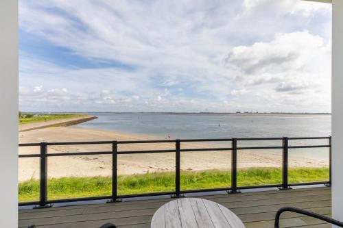a view of the beach from a balcony at Vakantiewoning aan het water - met 2 balkons - Vista Maris - Nr 38 in Sint Annaland