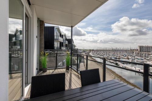 a balcony with a table and chairs and a harbor at Vakantiewoning aan het water - met 2 balkons - Vista Maris - Nr 38 in Sint Annaland