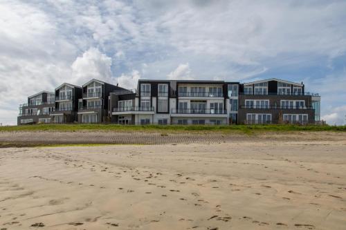 a building on the beach next to the sand at Vakantiewoning aan het water - met 2 balkons - Vista Maris - Nr 38 in Sint Annaland