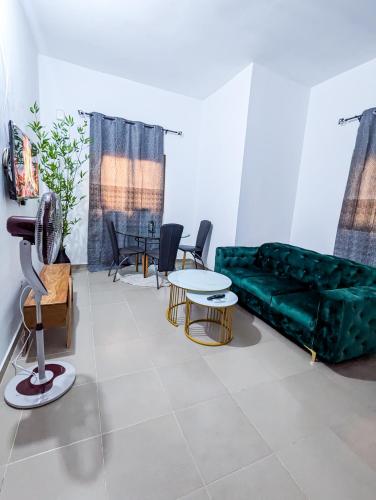 a living room with a green couch and a table at La perle océanique Calme et moderne près de l'océan in Lomé