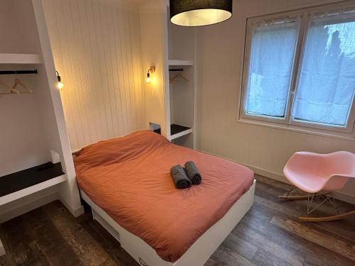 a bedroom with a bed with a pair of shoes on it at Villa ISKA - 6Velos-Calme-Piscine-Moderne-Centre-Port-Plages in La Tremblade