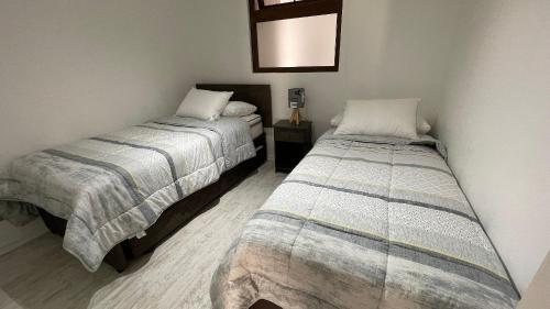 two beds in a small room with at Departamentos con hermosas vistas al mar in Coquimbo