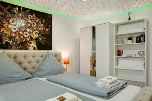 a bedroom with a bed and a painting on the wall at Modern Apartments Neuburg 2 - New in Neuburg an der Donau