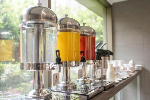 a row of different colored drinks in containers on a counter at abba Presidente Suites Santiago in Santiago