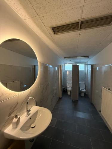 a bathroom with a sink and a mirror and two toilets at ENSAS rooms in Koblenz