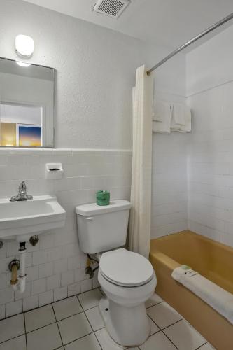 a white bathroom with a toilet and a sink at TRAVELER'S INN in Smithfield