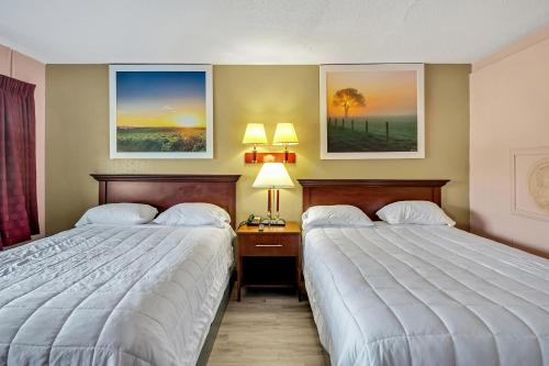 a hotel room with two beds and two lamps at TRAVELER'S INN in Smithfield