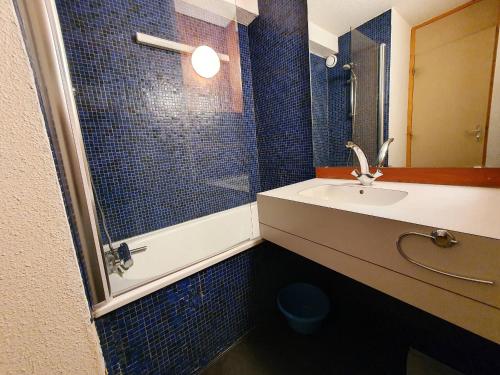 une salle de bain carrelée bleue avec un lavabo et une douche dans l'établissement Duplex 6 pers avec balcon aux Coches, proche pistes et commerces - FR-1-353-5, à La Plagne