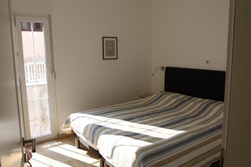a bed in a white room with a window at Pinna Nobilis Apartments - Ground Floor in Brodarica