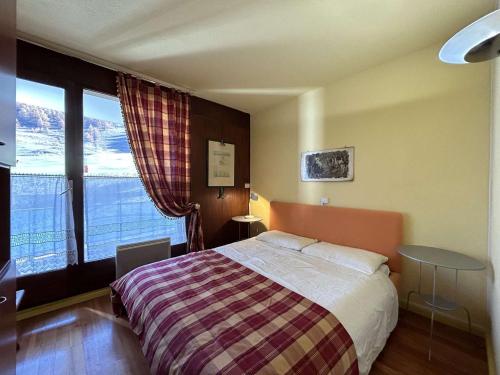 une chambre avec un lit et une grande fenêtre dans l'établissement Appartement skis aux pieds, 6 pers avec parking, Montgenèvre - FR-1-330D-7, à Montgenèvre
