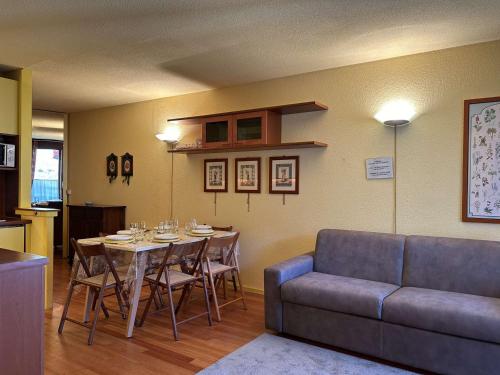 une salle à manger avec une table et un canapé dans l'établissement Appartement skis aux pieds, 6 pers avec parking, Montgenèvre - FR-1-330D-7, à Montgenèvre