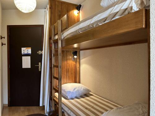 Cette chambre comprend 2 lits superposés et une porte. dans l'établissement Studio montagne 4 pers. avec balcon, pistes à 100m, parking, local à skis - Montgenèvre - FR-1-330D-77, à Montgenèvre