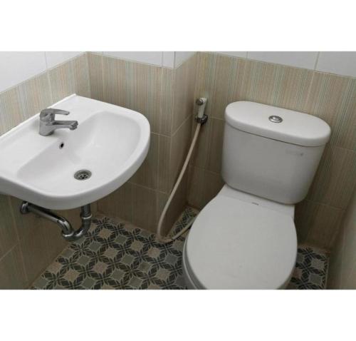 a bathroom with a white toilet and a sink at Hotel O Bontotangnga Homestay in Balangberu