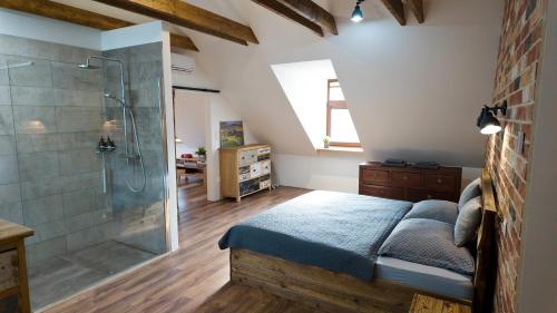 a bathroom with a shower and a bed in a room at Apartman Vulcano in Zvolen