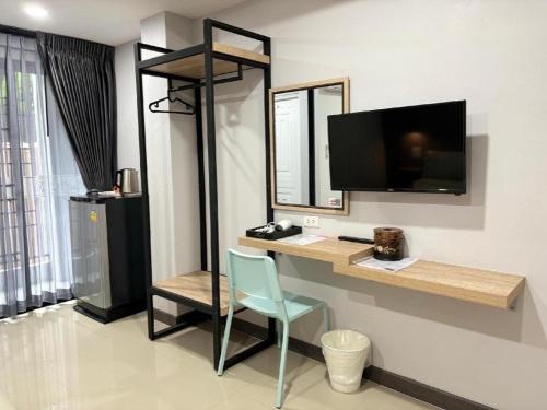 a room with a desk with a television and a chair at The Hub Hotel Surin in Surin