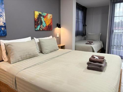 a bedroom with a large bed with towels on it at The Hub Hotel Surin in Surin