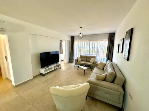 a living room with a couch and a tv at Retreat site, block A1, unit 1 in Küçükerenköy