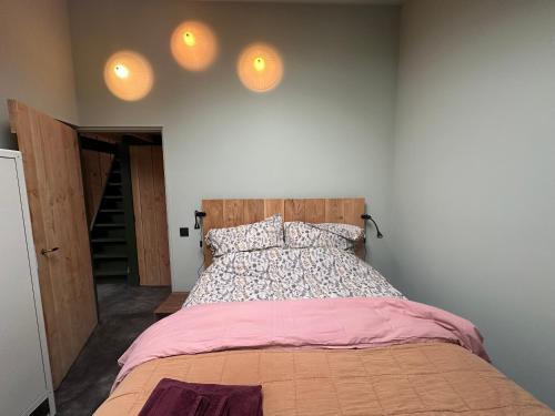 a bedroom with a bed and two lights on the wall at PieterBuur in Pieterburen