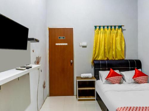 a room with a bed and a desk and a television at OYO 91296 Nagoya Guesthouse in Nagoya