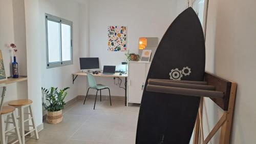 a room with a desk with a surfboard on the wall at The Wave Temple II in Las Palmas de Gran Canaria
