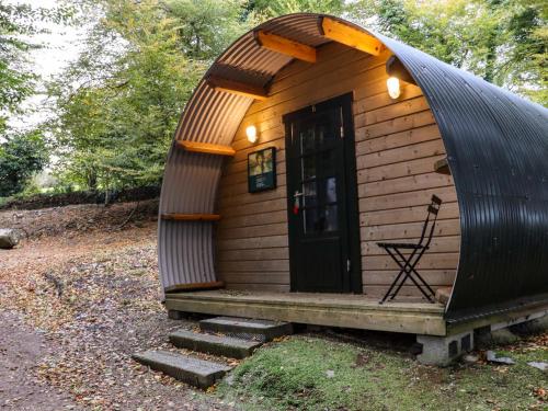 a small cabin in the woods with a door and stairs at Ballybeg Pod 10 in Arklow