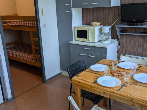 une chambre avec une table, un micro-ondes et un lit superposé dans l'établissement Studio lumineux 4 pers, proche télésiège et commerces, Orcières-Merlette - FR-1-262-175, à Orcières