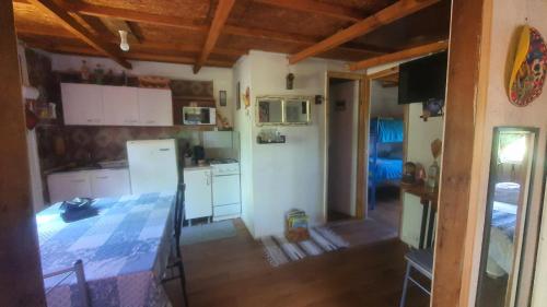 a kitchen with white cabinets and a refrigerator at Cabaña campestre a 7min de Osorno in Osorno