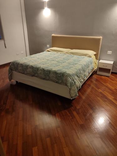 a bed in a bedroom with a wooden floor at San vito 9 - a in Agrigento